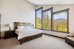 The spacious master bedroom has beautiful views of the mountains and slopes